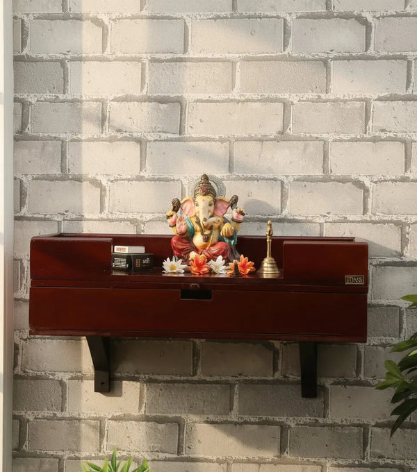 Wall-mounted wooden shelf with decorative items against a brick wall.