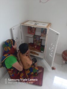 2 persons are praying in home temple